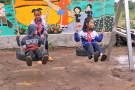 Các em nhỏ vui chơi trên chiếc xích đu mới. (Ảnh: Đình Đình)