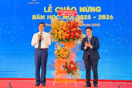 Phó Chủ tịch UBND tỉnh Lâm Hải Giang (bên trái) tặng hoa chúc mừng Trường Đại học Quang Trung tại lễ chào mừng năm học mới 2025-2026. 