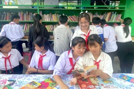 Các học sinh đọc sách tự chọn tại các kệ sách và từ xe Thư viện lưu động. Ảnh: T.N
