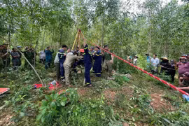 Các lực lượng phối hợp cứu người bị nạn lên khỏi miệng giếng. 