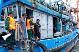 Cán bộ, chiến sĩ Đồn Biên phòng Cửa khẩu cảng Quy Nhơn tuyên truyền để các chủ tàu thuyền tránh bão. Ảnh: Công Cường