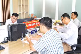 Cán bộ Trung tâm Phục vụ hành chính công xã An Nhơn Tây giải quyết hồ sơ, thủ tục đất đai cho người dân. Ảnh: V.L