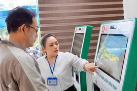 Hỗ trợ người dân thực hiện các bước tại KIOS TTHC thông minh tại Trung tâm Phục vụ hành chính công tỉnh. Ảnh: An Khang