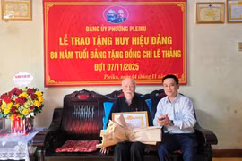 Đồng chí Nguyễn Xuân Phước-Tỉnh ủy viên, Bí thư Đảng ủy, Chủ tịch HĐND phường Pleiku (bìa phải) trao Huy hiệu 80 năm tuổi Đảng cho đồng chí Lê Thảng. Ảnh: Bá Bính