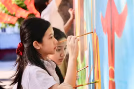 Học sinh Trường Hội nhập Quốc tế iSchool Quy Nhơn say sưa vẽ bích họa về chủ đề đất Võ trời Văn trên bức tường trắng. Ảnh: T.D