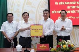 Bí thư Tỉnh ủy Hồ Quốc Dũng (thứ 2 từ trái sang) tặng quà cho lãnh đạo phường Quy Nhơn Đông. Ảnh: Nguyễn Hân