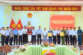 Phó Chủ tịch UBND tỉnh Nguyễn Tuấn Anh (thứ 10 từ phải sang) tặng quà của Tỉnh ủy, HĐND, UBND, Ủy ban MTTQ Việt Nam tỉnh cho lãnh đạo và Công an phường Hoài Nhơn Tây. Ảnh: Phi Long