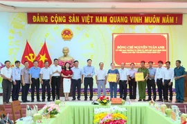 Phó Chủ tịch UBND tỉnh Nguyễn Tuấn Anh (thứ 10 từ phải sang) tặng quà của Tỉnh ủy, HĐND, UBND, Ủy ban MTTQ Việt Nam tỉnh cho lãnh đạo và Công an phường Hoài Nhơn Tây. Ảnh: Phi Long