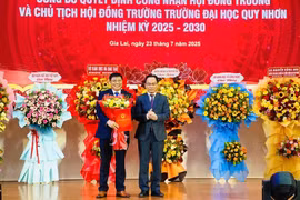 Thứ trưởng Bộ GD&ĐT Hoàng Minh Sơn (bìa phải) trao hoa và quyết định cho PGS.TS Nguyễn Quang Ngoạn-Chủ tịch Hội đồng trường Trường Đại học Quy Nhơn nhiệm kỳ 2025-2030. Ảnh: T.D