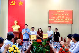 Phó Chủ tịch UBND tỉnh Lâm Hải Giang tặng quà cho lãnh đạo xã Phù Mỹ Bắc. Ảnh: Bình Dương