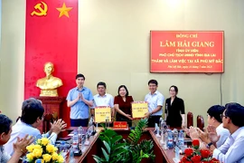 Phó Chủ tịch UBND tỉnh Lâm Hải Giang tặng quà cho lãnh đạo xã Phù Mỹ Bắc. Ảnh: Bình Dương