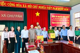 Phó Chủ tịch Thường trực UBND tỉnh Nguyễn Tuấn Thanh tặng quà cho tập thể Đảng ủy, HĐND, UBND, Ủy ban MTTQ Việt Nam xã Chư Păh. Ảnh: Ngọc Luận