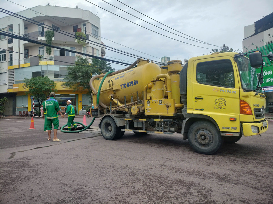 Công nhân Công ty CP Môi trường Bình Định thực hiện nạo vét các cụm hố ga ở đường Lê Duẩn (phường Quy Nhơn), đảm bảo khả năng tiêu thoát nước khi có mưa lớn xảy ra. Ảnh: Trọng Lợi nao-vet.jpg