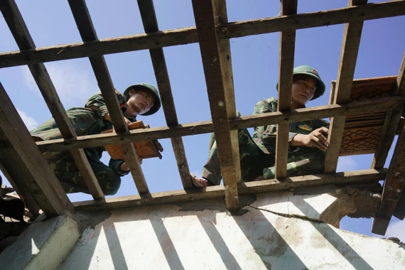 Bộ đội giúp dân lợp lại mái nhà.
