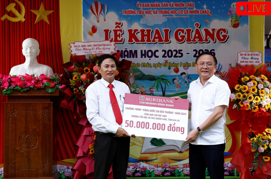 Lãnh đạo Agribank Bình Định (bìa phải) tặng quà cho Trường Tiểu học và THCS Nhơn Châu. Ảnh: Hồng Phúc mg-2596-8332.jpg