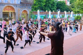 Các em học sinh được hướng dẫn một số động tác thể dục giữ gìn sức khỏe. Ảnh: Minh Ngọc