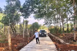 Ông Trần Trọng Bằng-Trưởng thôn Ia Tang chỉ con đường bê tông vừa được hoàn thành giúp người dân trong thôn đi lại thuận lợi hơn. Ảnh: Lê Nam