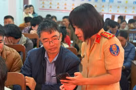 Cán bộ CSGT hướng dẫn thí sinh cài đặt ứng dụng VNeTraffic