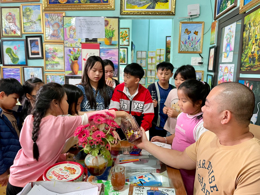 Anh Thành còn phát quà sau mỗi buổi học để tạo động lực cho các em nhỏ. Ảnh: Bích Ngọc