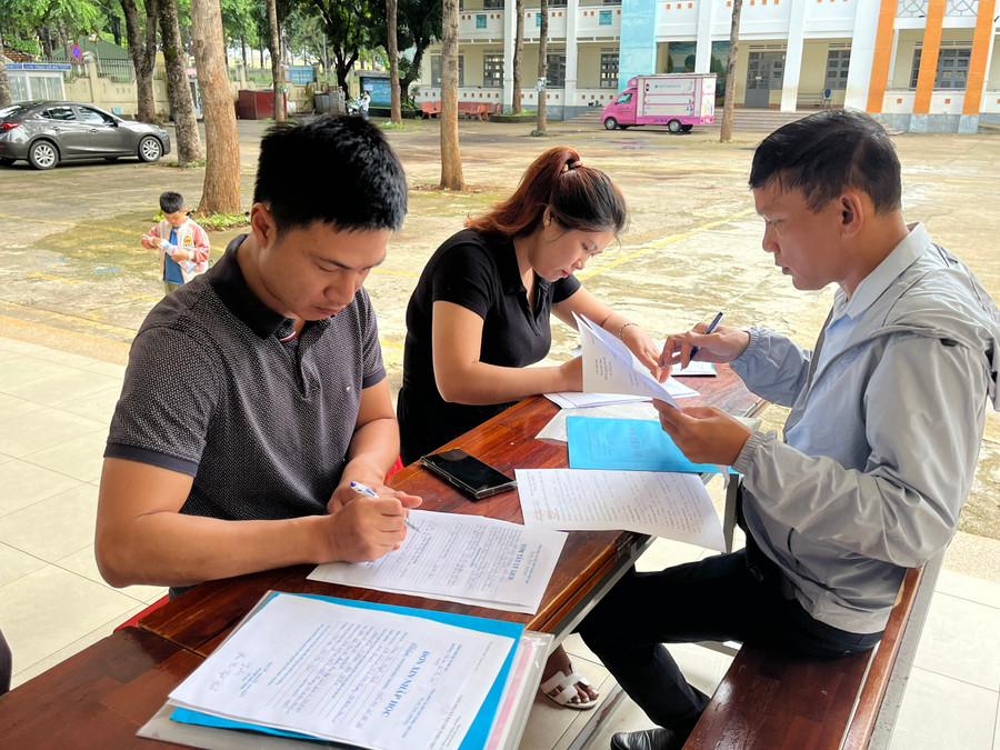 Các phụ huynh điền thông tin phiếu đăng ký nhập học cho con vào lớp 1 tại Trường Tiểu học Võ Thị Sáu (phường Hội Thương, TP. Pleiku). Ảnh: Hoàng Hoài