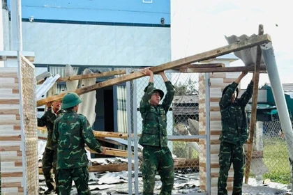 Cán bộ, chiến sĩ Sư đoàn 2 hỗ trợ người dân phường Hoài Nhơn Đông sửa chữa lại nhà ở. 