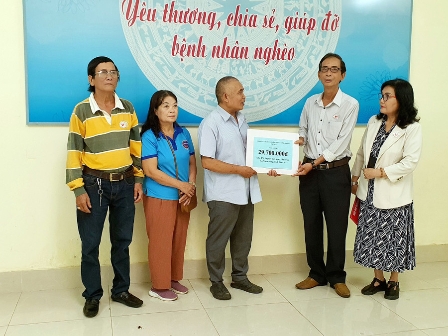 Phó Chủ tịch Hội Bảo trợ bệnh nhân nghèo tỉnh Trần Đình Ký trao 29,7 triệu đồng cho gia đình bệnh nhân Phạm Văn Lượng bị nhiễm trùng huyết. Ảnh: KIM HƯỜNG lan-toa-long-nhan-ai.jpg