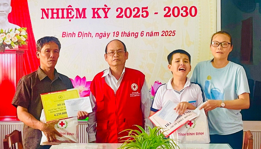 Ông Hà Văn Cát (Chủ tịch Hội Chữ thập đỏ tỉnh) trao tiền cho 2 em Mạnh và An. Ảnh: Ngọc Huy trao-qua.jpg