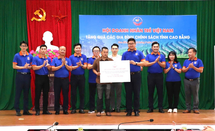 ທ່ານ ຫວູຮົ່ງກວນ (ທີ 4 ຈາກຂວາ) ຕາງໜ້າສະມາຄົມນັກທຸລະກິດໜຸ່ມຫວຽດນາມ ມອບຂອງຂວັນໃຫ້ບັນດາຄອບຄົວນະໂຍບາຍຢູ່ແຂວງ ກາວບັ່ງ. ພາບ: NVCC doanh-nhan-tre-vu-hong-quan-trao-nha-cao-bang.jpg