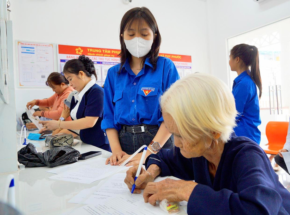 Được sự hỗ trợ của đoàn viên thanh niên và công chức chuyên môn, người cao tuổi chỉ cần thực hiện bước cuối cùng là ký tên vào hồ sơ. Ảnh: N.M 1bg-4664.jpg