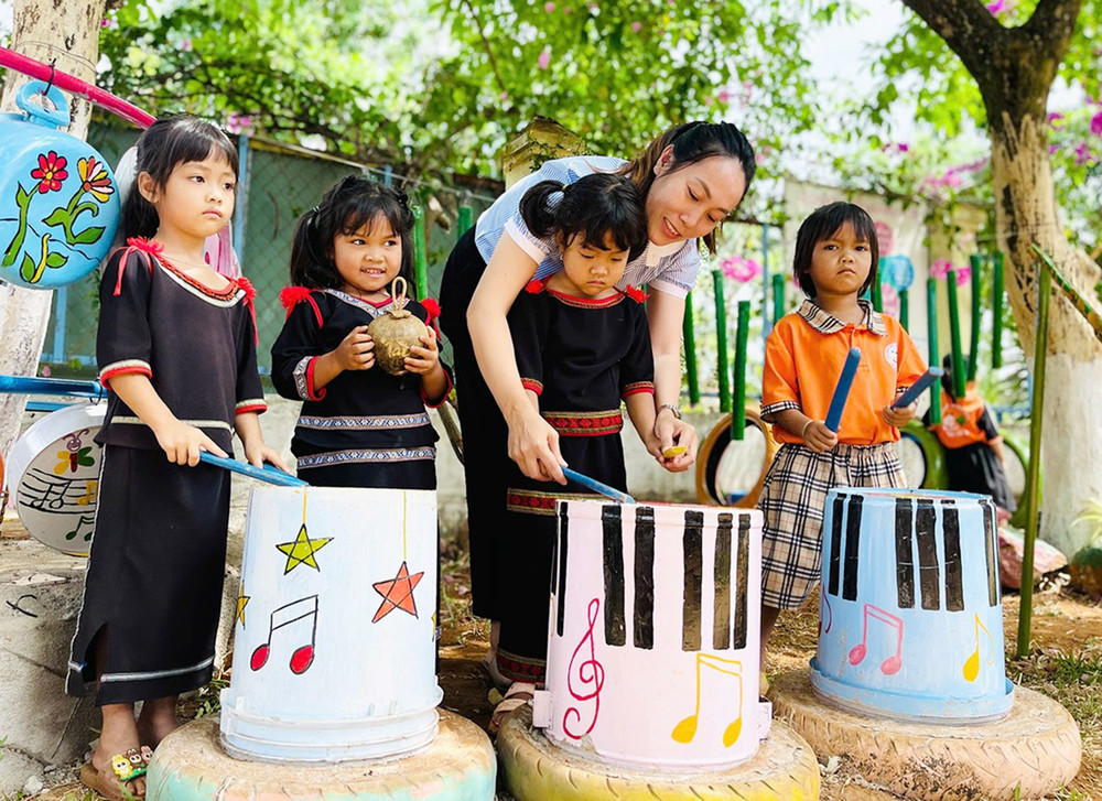 Giáo viên Trường Mẫu giáo Hoa Sữa (xã Ia Kly, huyện Chư Prông) biến vỏ thùng sơn thành đồ dùng dạy học môn Âm nhạc. Ảnh: T.D 1td.jpg
