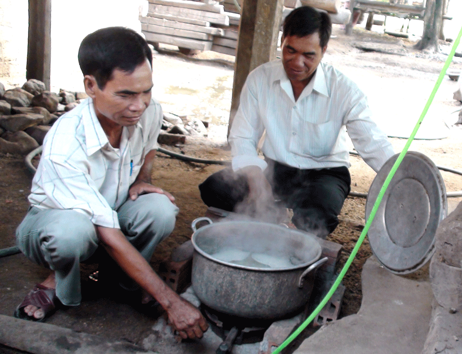 Ông Rahlan Vang (bên trái) sử dụng gas để nấu thức ăn cho heo. Ảnh: Q.T Ông Rahlan Vang (bên trái) sử dụng gas để nấu thức ăn cho heo. Ảnh: Q.T