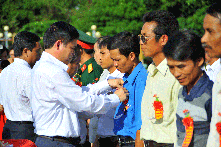 Gắn Huy hiệu Bác Hồ. Ảnh: N.G Ảnh: N.G