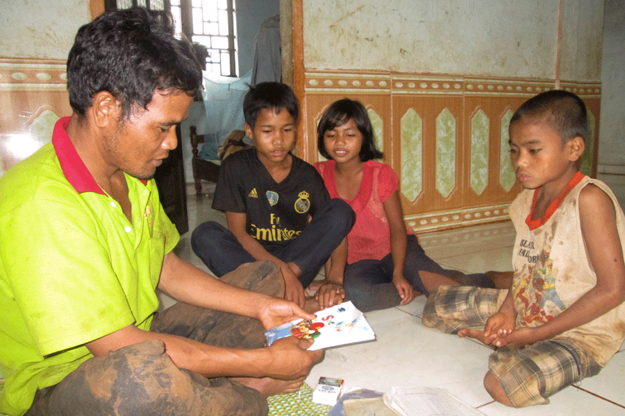 Anh Kpah Ớt chuẩn bị sách vở cho các con tới trường. Ảnh: Mai Ka