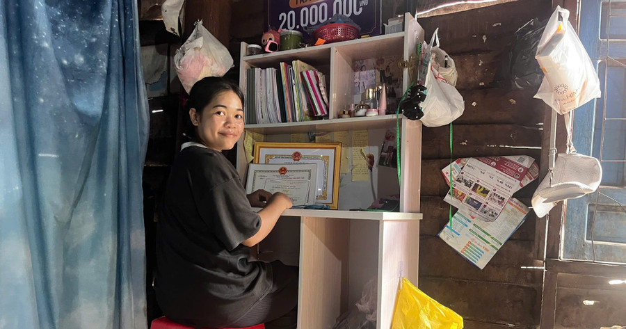 Em Siu H’Suyn bên góc học tập nhỏ của mình. Ảnh: H.H 1753366239731.jpg