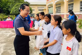 Bà Ksor H'Khuyên-Phó Chủ tịch UBND thị xã tặng quà cho các em học sinh có hoàn cảnh khó khăn nhân dịp Tết Trung thu. Ảnh: Vũ Chi