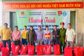 Ban tổ chức tặng quà cho các hộ gia đình có hoàn cảnh khó khăn trên địa bàn thị trấn Phú Túc. Ảnh: Vũ Chi