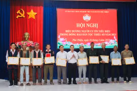 Phó Bí thư Huyện ủy Vũ Hồng Duy (đứng giữa) tặng giấy khen cho người uy tín tiêu biểu trên địa bàn. Ảnh: Vũ Chi