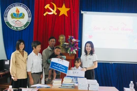 Đại diện Công ty, Ban Giám hiệu nhà trường trao tặng học bổng cho 2 em học sinh mồ côi của xã Ia Broăi. Ảnh: Vũ Chi