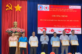 Phó Chủ tịch Thường trực UBND huyện Nguyễn Ngọc Ngô (đứng giữa) tặng giấy khen cho 6 tập thể có thành tích xuất sắc trong công tác hiến máu tình nguyện. Ảnh: Vũ Chi