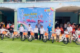 Ban tổ chức tặng xe đạp cho học sinh nghèo vượt khó của Trường Tiểu học và THCS Quang Trung. Ảnh: Vũ Chi