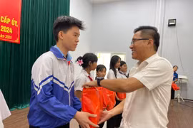 Chủ tịch UBND thị xã Nguyễn Trường Sơn trao quà cho các em học sinh tham gia hội nghị. Ảnh: Vũ Chi