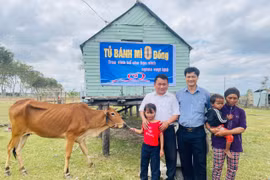 Đại diện Tủ bánh mì 0 đồng trao bò sinh sản cho em Đinh Thảo (học sinh lớp 2.1, Trường Tiểu học và THCS Đinh Núp) Ảnh Vũ Chi