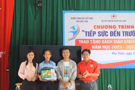 Đại diện hội từ thiện, Hội Chữ thập đỏ huyện Phú Thiện và cô Hoàng Thị Diệu Loan tặng quà cho em Vũ Thị Hằng (học sinh mồ côi cả cha lẫn mẹ, Trường THPT Trần Quốc Tuấn). Ảnh: Vũ Chi