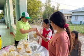 Chị Nguyễn Thị Tâm (bìa trái) cẩn thận đóng hũ từng suất ăn sáng trước khi phát cho bệnh nhân. Ảnh: Vũ Chi