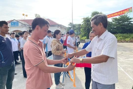 Ông Ksor Vinh-Phó Bí thư Thường trực Thị ủy (bìa phải) tặng cờ lưu niệm cho các đoàn vận động viên tham gia hội thi thể thao các dân tộc thiểu số. Ảnh: Vũ Chi