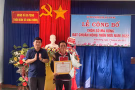 Phó Chủ tịch UBND huyện Phú Thiện Nguyễn Anh Tuấn (bìa trái) trao quyết định công nhận đạt chuẩn nông thôn mới cho cán bộ và nhân dân thôn Sô Ma Rơng. Ảnh: Vũ Chi