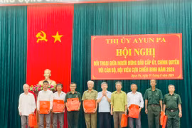 Bí thư Thị ủy Ayun Pa Trần Quốc Khánh (thứ 5 từ phải sang) tặng quà cho Chi hội trưởng Chi hội Cựu chiến binh tiêu biểu. Ảnh: Vũ Chi