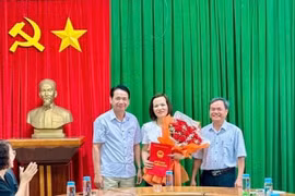 Phó Chủ tịch HĐND thị xã Mai Thế Phụng (bìa trái) và Phó Chủ tịch UBND thị xã Đặng Xuân Toàn (bìa phải) trao quyết định và tặng hoa chúc mừng tân Chánh Văn phòng HĐND&UBND thị xã Ảnh Nguyễn Sang