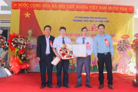 Bí thư Huyện ủy Nguyễn Minh Trưởng (bìa phải) và Phó Chủ tịch UBND huyện Ksor Suy (bìa trái) trao bằng công nhận Trường đạt chuẩn quốc gia mức độ 1 cho Trường Tiểu học Lê Văn Tám. Ảnh: Vũ Chi