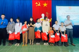 Lãnh đạo Thị Đoàn, Hội Chữ thập đỏ, Phòng Lao động-Thương binh và Xã hội thị xã trao quà cho các em học sinh có hoàn cảnh khó khăn. Ảnh: Vũ Chi